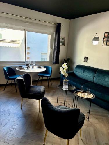 a living room with a couch and tables and chairs at Coeur De Plage - Studio Royan Hyper Centre - Classé 3 étoiles - 2 pers - 150m plage in Royan