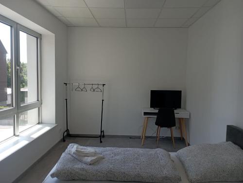 a white room with a bed and a television at Monteurwohnung Monti 2 in Saarbrücken