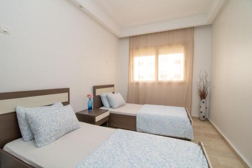 a bedroom with two beds and a window at Mamounia Horizon in Casablanca