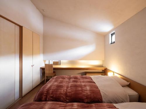 a bedroom with a bed and a desk in it at 小樽旅亭 蔵群 in Otaru