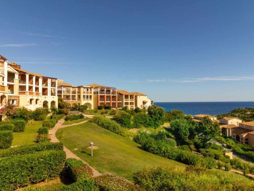 - une vue sur un complexe avec l'océan en arrière-plan dans l'établissement Studio 4 pers, terrasse couverte, piscine et parking, Cap Esterel - FR-1-504-653, à Saint-Raphaël