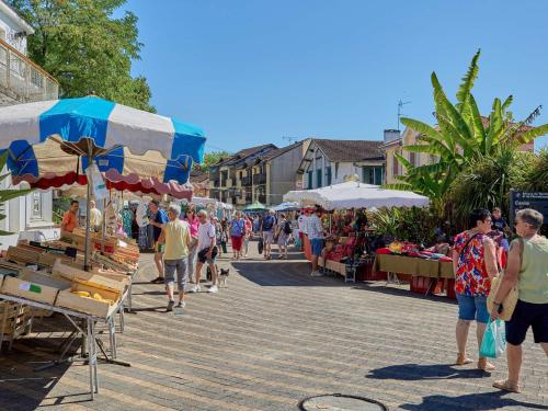 a group of people walking through a market with umbrellas at Studio lumineux avec balcon exposé sud à Barbotan - FR-1-841-31 in Barbotan-les-Thermes