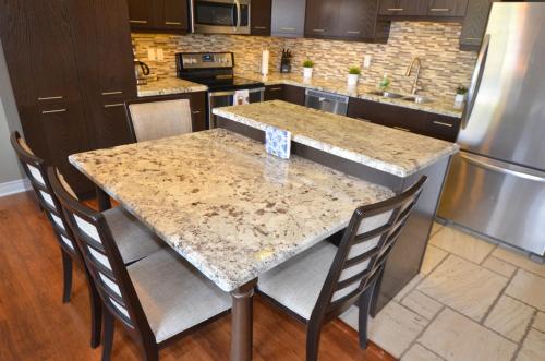 a kitchen with a marble table and chairs at The SoMa Furnished Residences in Hamilton