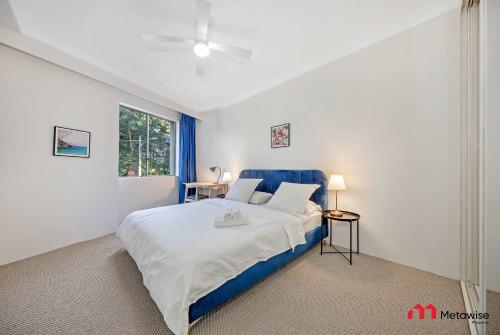 a bedroom with a blue and white bed and a window at MetaWise Cozy 1BR City Pad W Parking Near RPA & Sydney Uni in Sydney