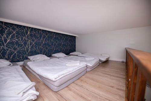 three beds in a room with a wall at City Place Noclegi in Wrocław
