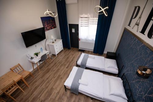 a living room with two beds and a television at City Place Noclegi in Wrocław