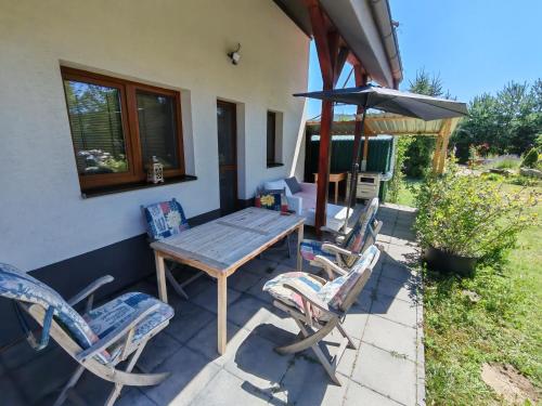 a patio with a table and chairs and an umbrella at Nosce Te Ipsum in Sokolníky
