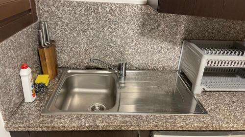 a kitchen counter with a stainless steel sink at Beachfront Apartment with Pool & Stunning View in Salalah