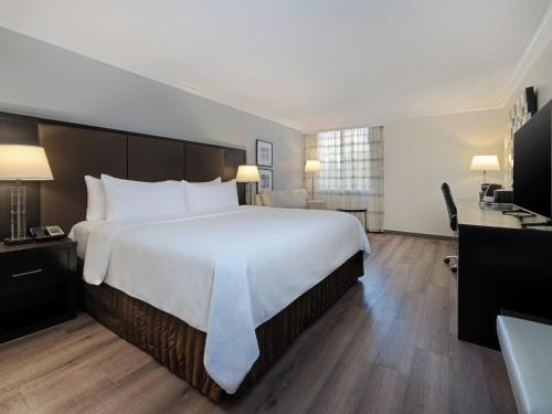 a hotel room with a large bed and a television at Crowne Plaza Suffern-Mahwah by IHG in Suffern