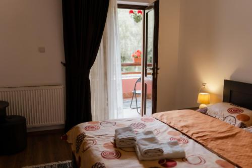 a bedroom with a bed with two towels on it at Pensiunea Bucur in Dămuc