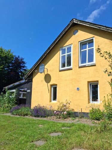 a yellow house with a satellite at Hyggeligt hus på landet in Ansager