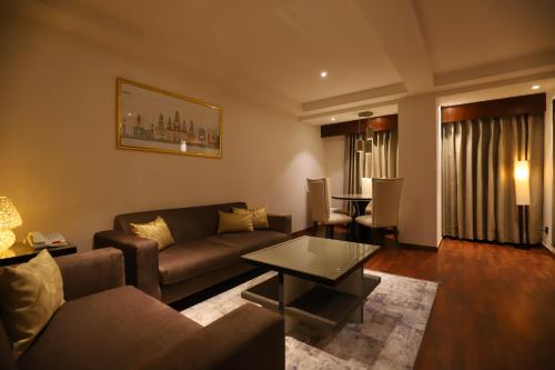 a living room with a couch and a table at The Pristine Hotel in Kānpur