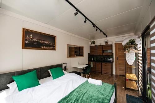 a bedroom with a large bed with green pillows at City Place Noclegi in Wrocław