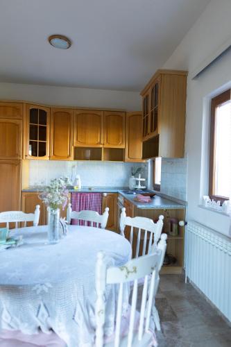 a kitchen with a table with white chairs and a kitchenventory at Stella's Home in Čitluk