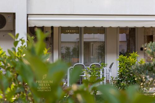 a table and chairs in front of a building at Premium Melia Garden Apartment in Lalzit Bay