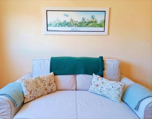 a white couch with pillows sitting under a picture at Miramar 2 - San Sebastin de La Gomera in San Sebastián de la Gomera