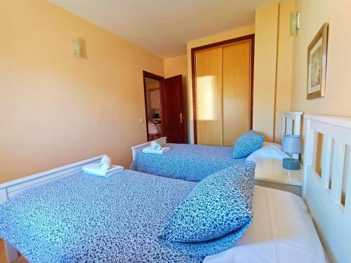 two beds with blue pillows in a room at Miramar 2 - San Sebastin de La Gomera in San Sebastián de la Gomera