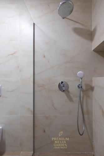 a shower with a glass door in a bathroom at Premium Melia Garden Apartment in Lalzit Bay