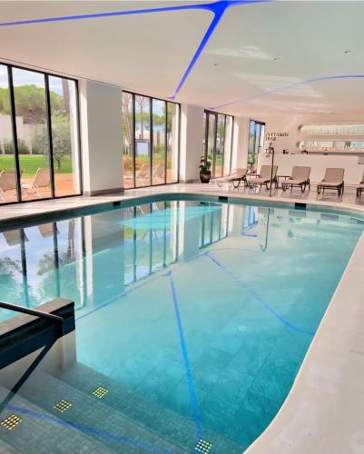 a large swimming pool with blue water in a building at Premium Melia Garden Apartment in Lalzit Bay