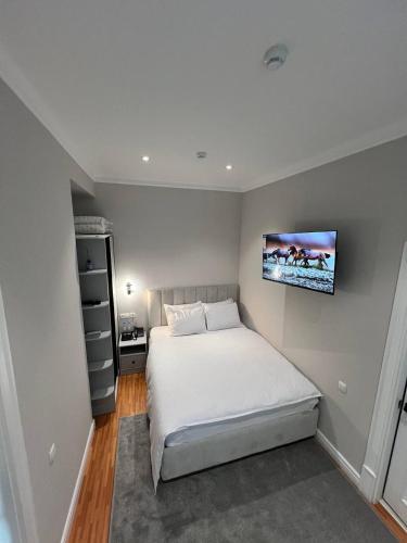 a bedroom with a bed and a tv on the wall at Qadim Hotel in Samarkand