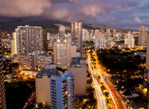 a city at night with buildings and traffic at Ilikai Lite in Honolulu