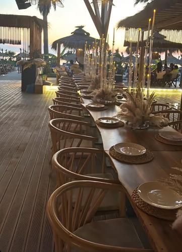 a row of tables and chairs on a deck at Premium Melia Garden Apartment in Lalzit Bay