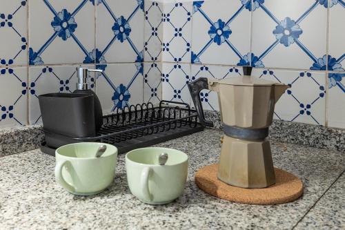 a coffee maker and two cups on a counter at Dimora Concept - Casa Laetitia in Pornassio