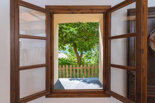 an open window with a view of a tree at Dimora Concept - Casa Laetitia in Pornassio