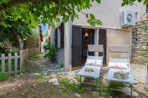 two chairs sitting in front of a house at Dimora Concept - Casa Laetitia in Pornassio
