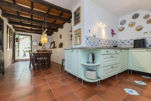 a kitchen with blue cabinets and a table in a room at Dimora Concept - Casa Laetitia in Pornassio