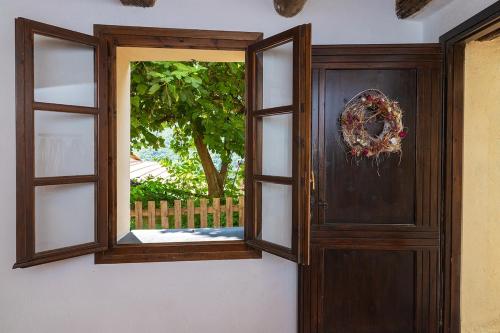a wooden door with a window in a room at Dimora Concept - Casa Laetitia in Pornassio