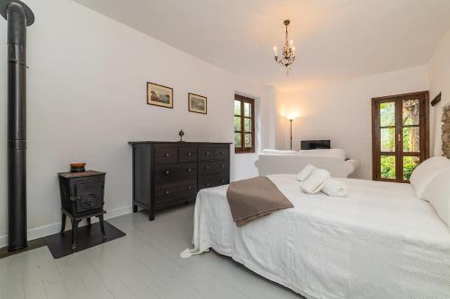 a white bedroom with two beds and a dresser at Dimora Concept - Casa Laetitia in Pornassio