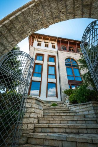 a building with stairs in front of a building at Sharm Hotel Luxury in Gjirokastër