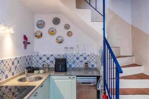 a small kitchen with a sink and a staircase at Dimora Concept - Casa Laetitia in Pornassio