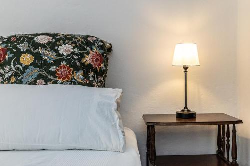 a bed with a pillow and a lamp on a table at Dimora Concept - Casa Laetitia in Pornassio