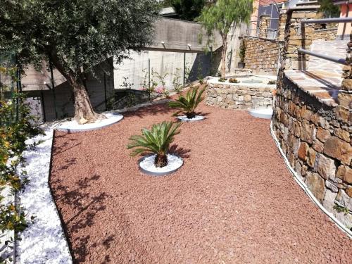 a garden with two potted plants and a stone wall at Vlletta da Amare in Imperia