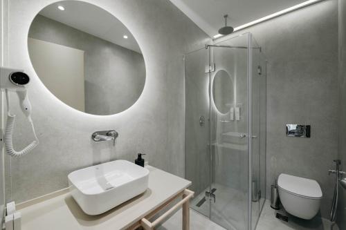 a bathroom with a sink and a shower with a mirror at Sharm Hotel Luxury in Gjirokastër