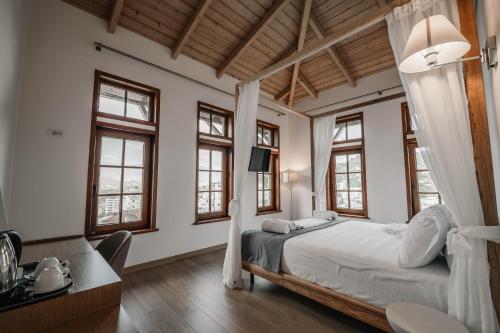 a bedroom with a bed and some windows at Sharm Hotel Luxury in Gjirokastër