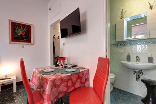 une table de salle à manger avec des chaises rouges et un évier dans l'établissement Appartamento Lily, à Florence