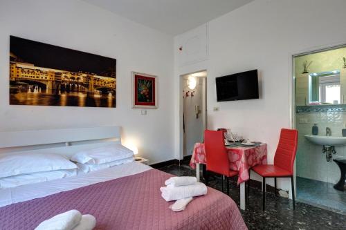 une chambre avec un lit, une table et un lavabo dans l'établissement Appartamento Lily, à Florence