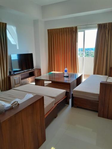 a hotel room with two beds and a television at Ocean Breeze Sea View Luxury Apartments in Negombo