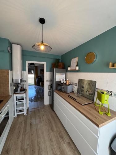 - une cuisine avec des murs verts et un comptoir dans l'établissement T3 Cosy, à Ajaccio