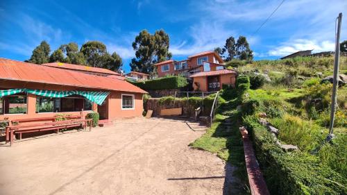 a house sitting on top of a dirt road at LA MANSION DEL SOL LODGE Taquile island in Isla Taquili