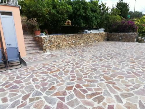 a patio with a stone floor and a wall at Vlletta da Amare in Imperia