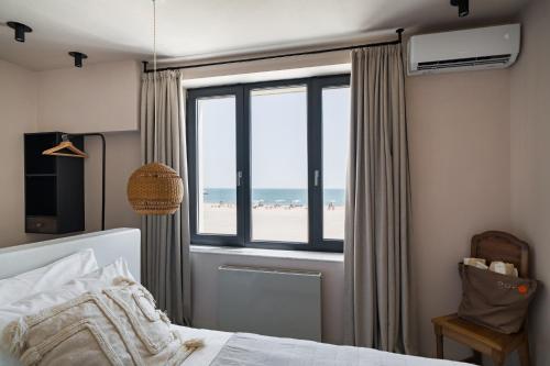 a bedroom with a bed and a view of the beach at Euforia Retreat and Spa in Eforie Nord