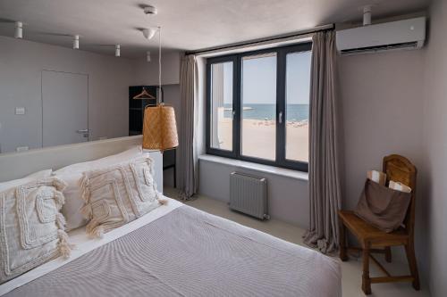 a bedroom with a bed with a view of the beach at Euforia Retreat and Spa in Eforie Nord