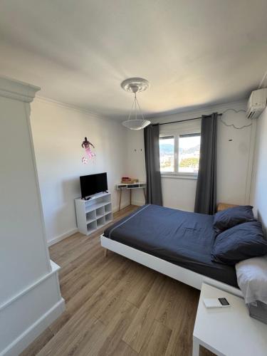 une chambre avec un lit et une télévision dans l'établissement T3 Cosy, à Ajaccio
