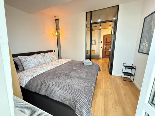 a bedroom with a large bed and a hallway at Nice Apartment in the Center, with Balcony in Crăsnăşeni