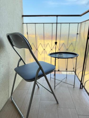 a chair and a table in a room at Nice Apartment in the Center, with Balcony in Crăsnăşeni