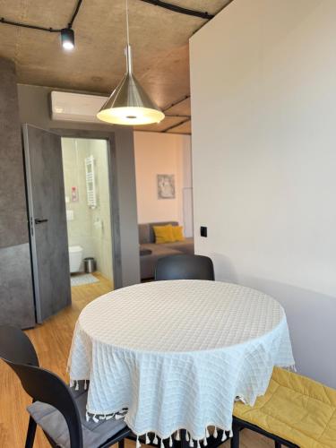 a dining room with a white table and chairs at Nice Apartment in the Center, with Balcony in Crăsnăşeni